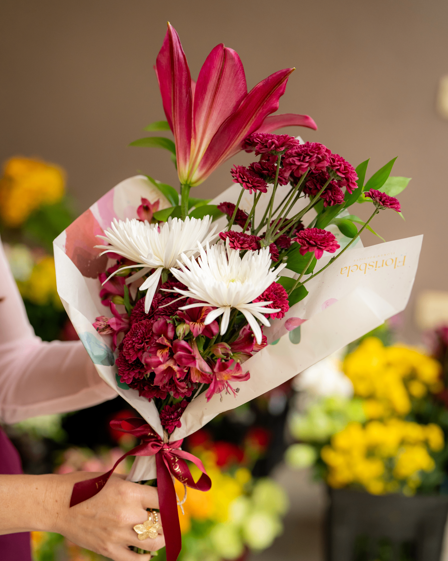Buquê Florisbela em vaso de cristal com rosas verdes e cor-de-rosa.