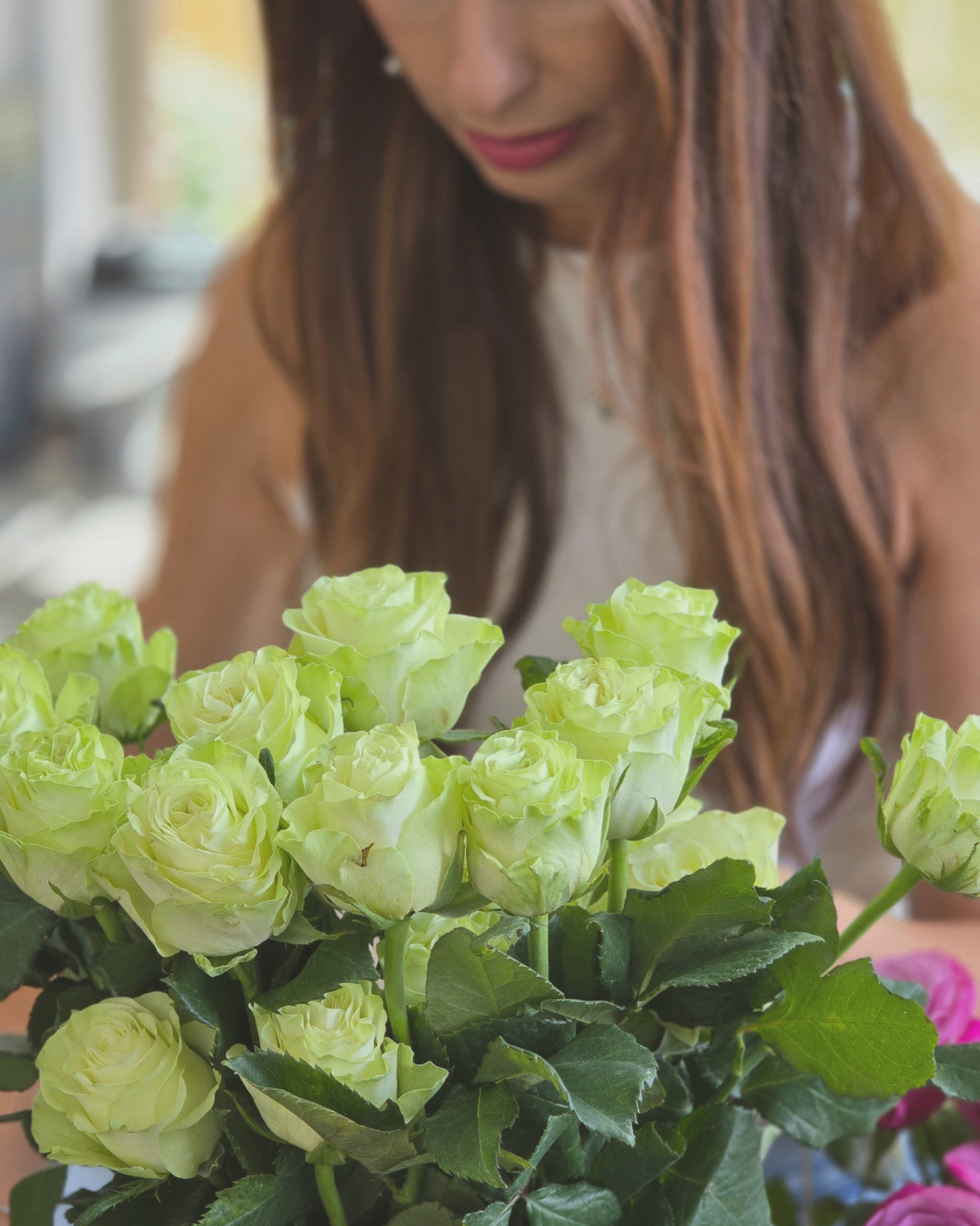 Buquê Florisbela em vaso de cristal com rosas verdes e cor-de-rosa.