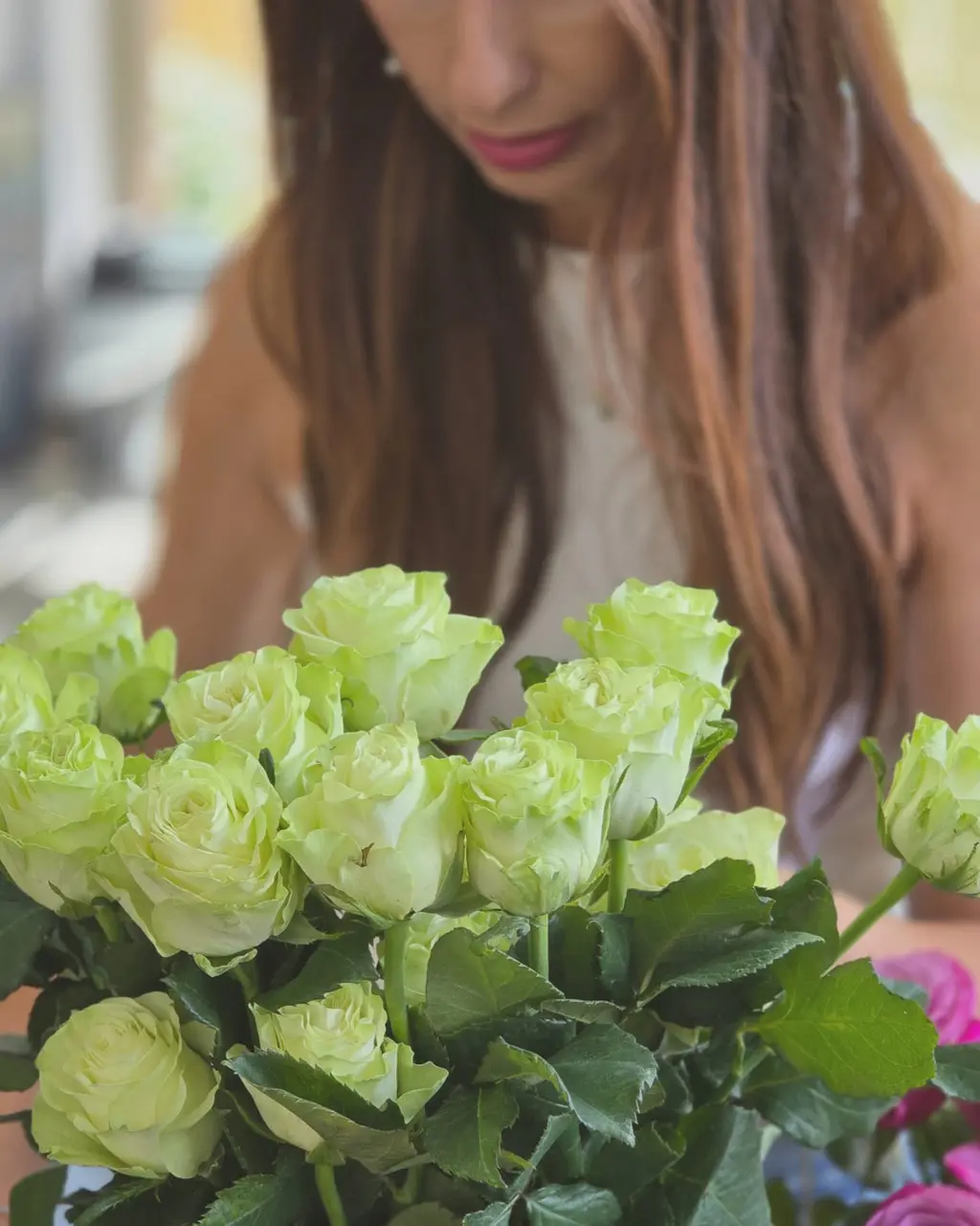 Buquê Florisbela em vaso de cristal com rosas verdes e cor-de-rosa.